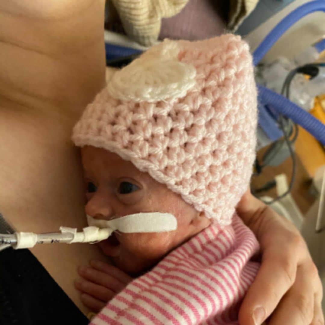 Baby Caroline being held by her mother.